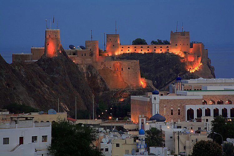 tourists admiring the views of muttrah corniche, muttrah fort, jalali and mirani fort during the muscat day tour on oman muscat day tour from abu dhabi