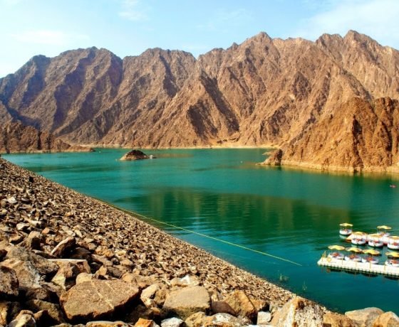 tourists enjoying the wadi in hatta, swimming in wadi, splashing in wadi water with secret waterfalls, on a hatta mountain safari tour