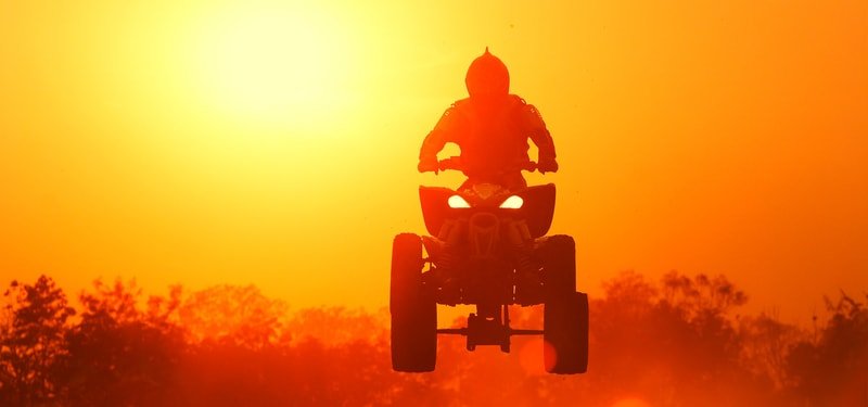 tourist enjoying the adrenaline puming rides on the ras al khaimah desert in brand new quad / atv bike on quad biking tour in ras al khaimah desert