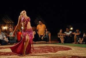 tourists enjoying bbq dinner in ras al khaimah desert, 4x4 jeep safari, belly dance, camel rides , quad biking in ras al khaimah desert on suncity desert safari ras al khaimah